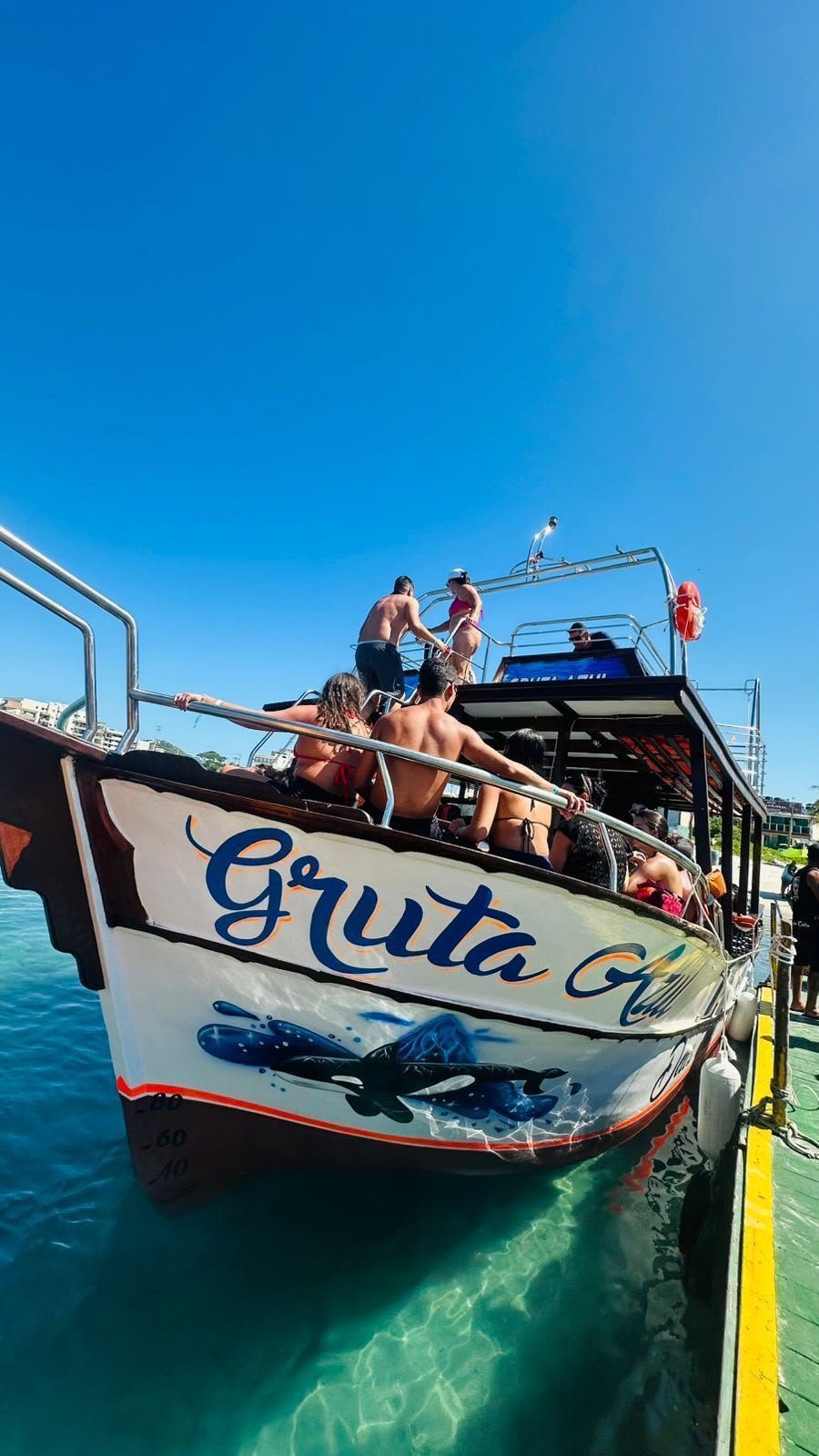 Proa da embarcação Gruta Azul atracada no cais da Praia dos Anjos